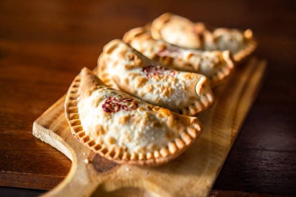 Close-up view of freshly baked empanadas on a plate.